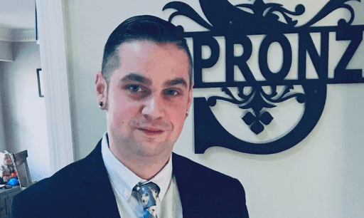 Headshot of Eric Spronz, NP, posed in front of a SPROZN medical backdrop, highlighting his role as a clinical partner with Nextvisit AI.